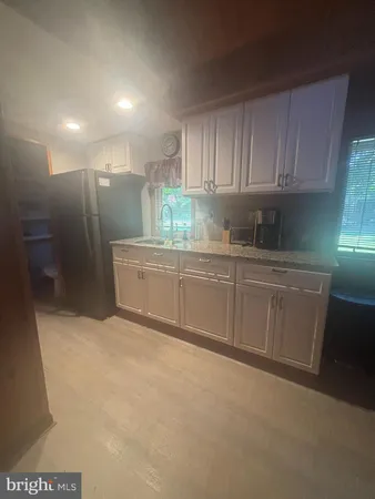 a kitchen with stainless steel appliances a sink a refrigerator and cabinets