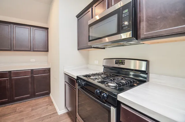 a kitchen with wooden cabinets and a stove top oven