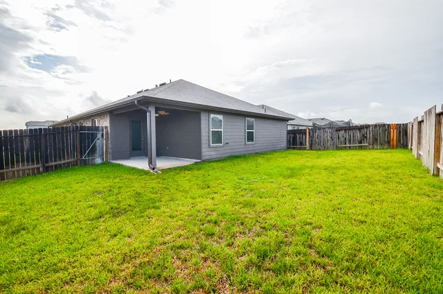 a view of a house with a yard and sitting area
