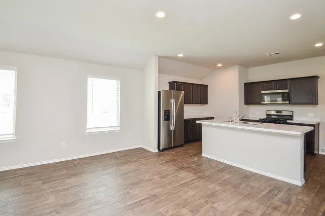 a kitchen with stainless steel appliances a refrigerator sink and microwave