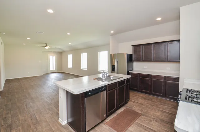 a kitchen with stainless steel appliances granite countertop a sink stove and wooden floor