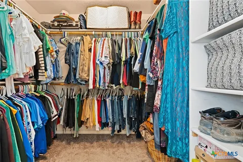 a view of walk in closet with clothes