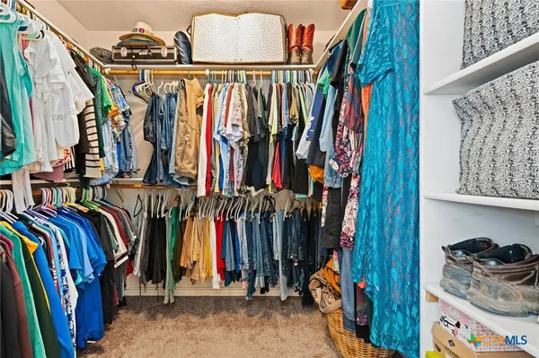 a view of walk in closet with clothes