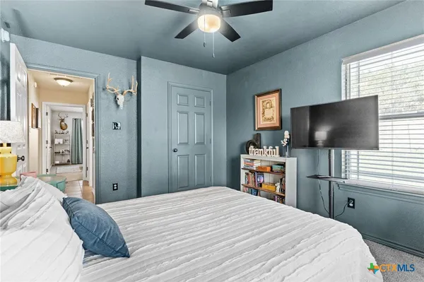 a bedroom with a bed and a flat tv screen on dresser and a flat tv screen on dresser