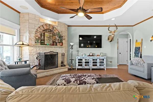 a living room with furniture a flat screen tv and a fireplace