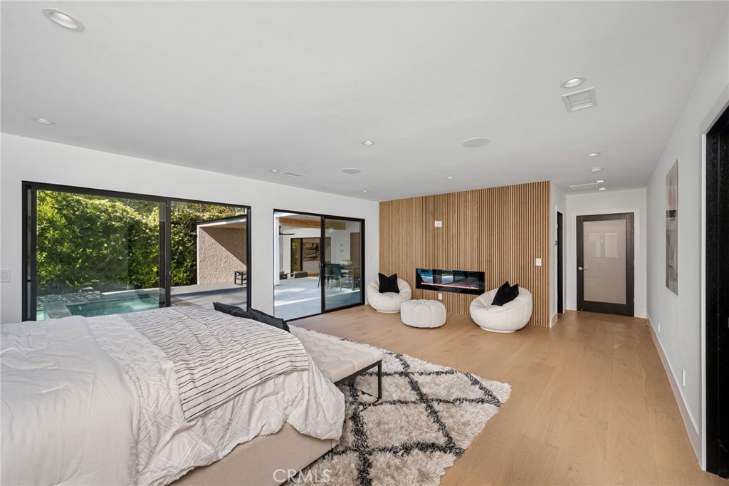 4731 Caritina Drive Tarzana, CA 91356 - Photo 31 of 42 a spacious bedroom with a bed a table and large window