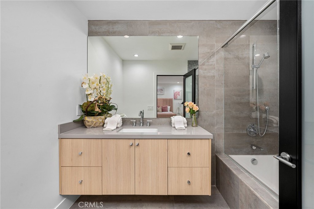 4731 Caritina Drive Tarzana, CA 91356 - Photo 35 of 42 a bathroom with a sink double vanity granite tub shower and a mirror
