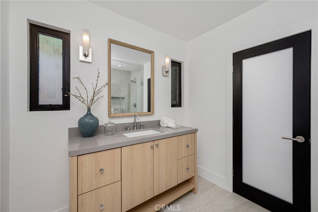 4731 Caritina Drive Tarzana, CA 91356 - Photo 37 of 42 a bathroom with a granite countertop sink and a mirror