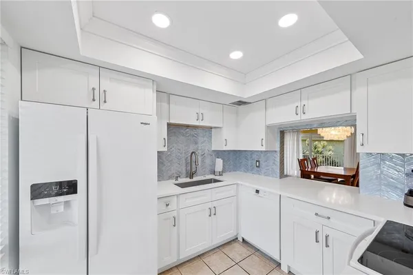 a kitchen with white cabinets and white appliances