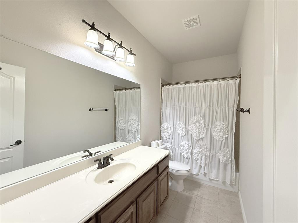 1301 Meadow Ranch Road McKinney, TX 75071 - Photo 26 of 40 Bathroom with vanity, light tile patterned floors, and shower / bathtub combination with curtain