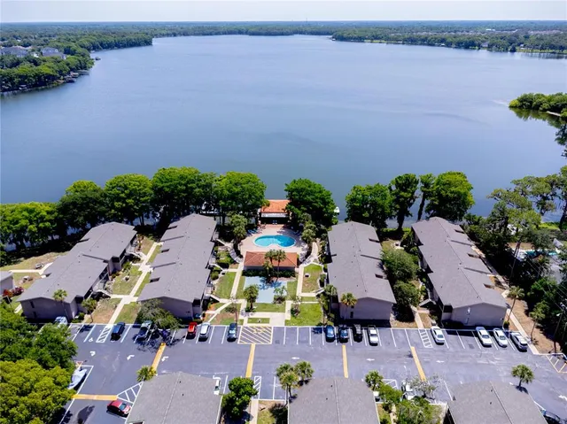 an aerial view of a house with outdoor space and lake view in back