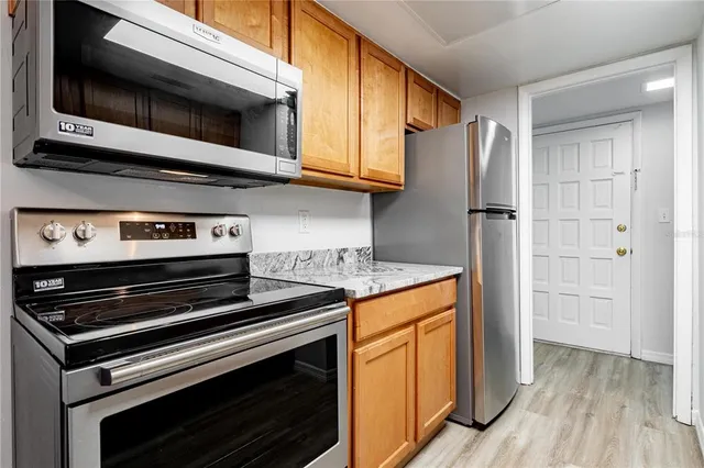 a kitchen with stainless steel appliances granite countertop a stove and a microwave