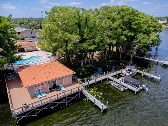 an aerial view of a house with swimming pool a yard and outdoor seating