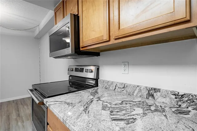 a kitchen with granite countertop a sink and a stove top oven