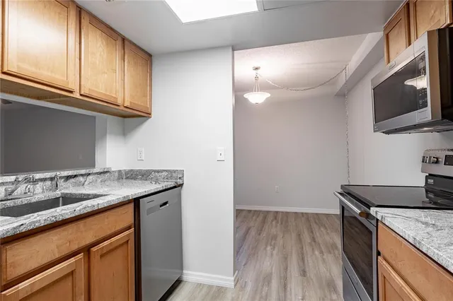 a kitchen with granite countertop wooden cabinets and a sink