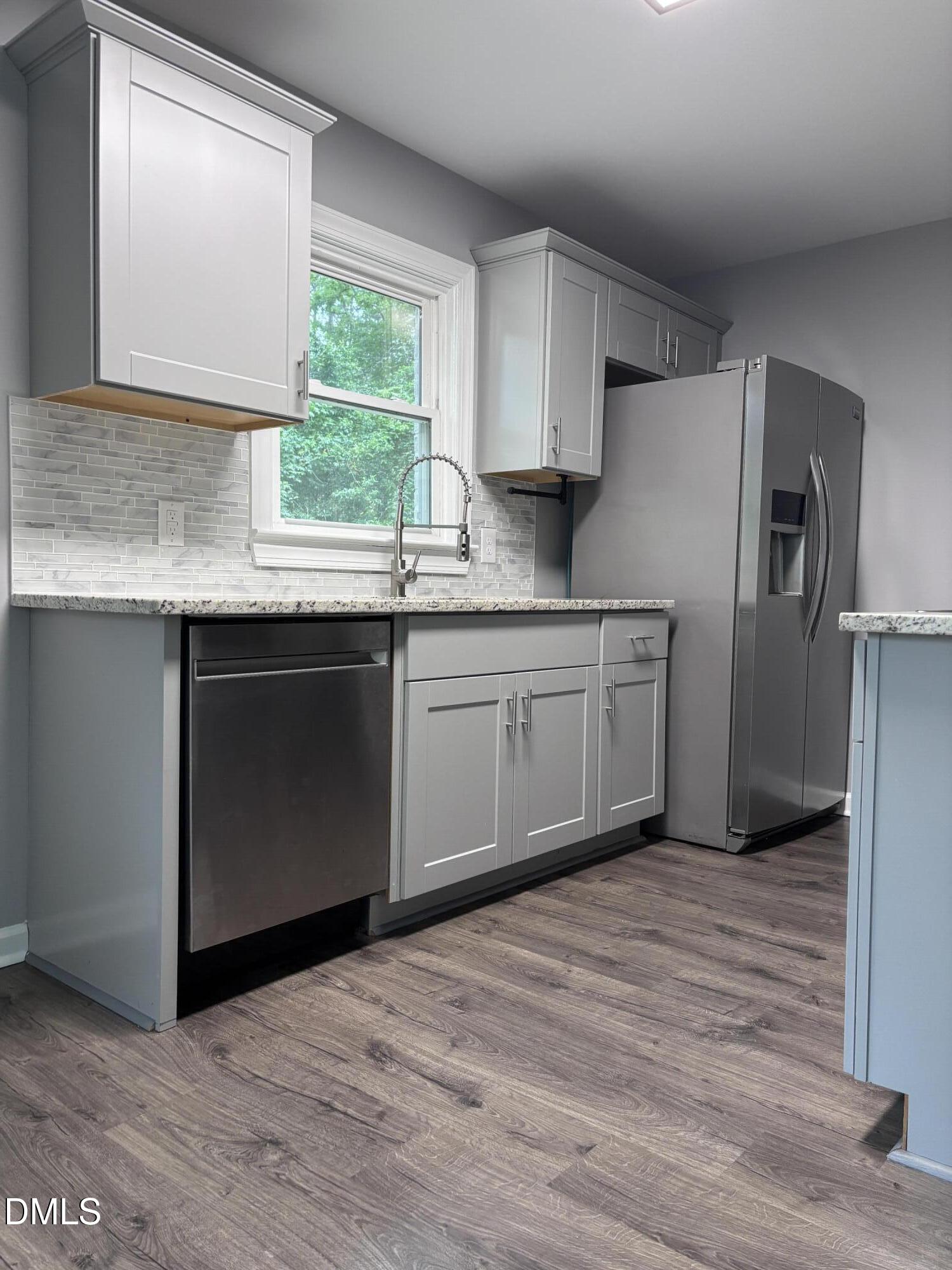 504 St Andrews Church Road Sanford, NC 27332 - Photo 4 of 22 a kitchen with stainless steel appliances granite countertop a sink a stove a refrigerator and island with wooden floor