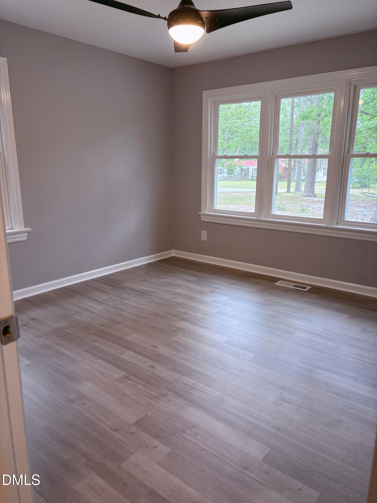 504 St Andrews Church Road Sanford, NC 27332 - Photo 9 of 22 an empty room with wooden floor and windows