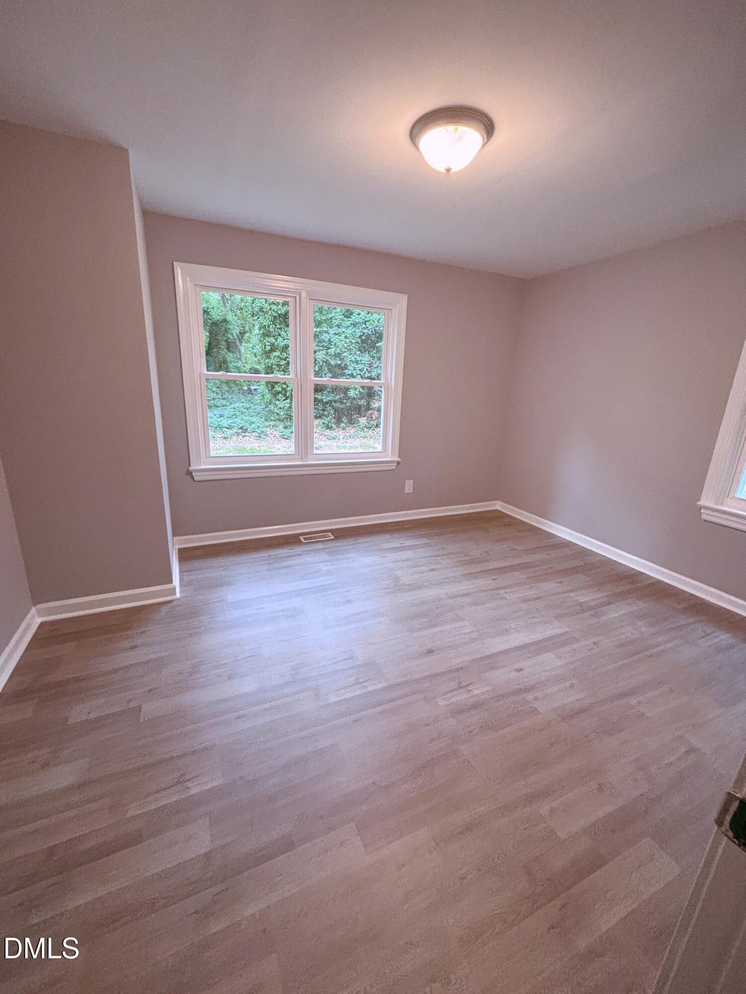 504 St Andrews Church Road Sanford, NC 27332 - Photo 10 of 22 an empty room with wooden floor and windows