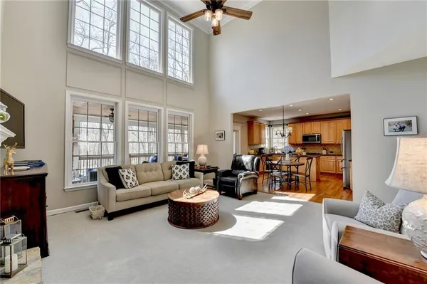 a kitchen with stainless steel appliances granite countertop a stove a sink a microwave a dining table and chairs with wooden floor