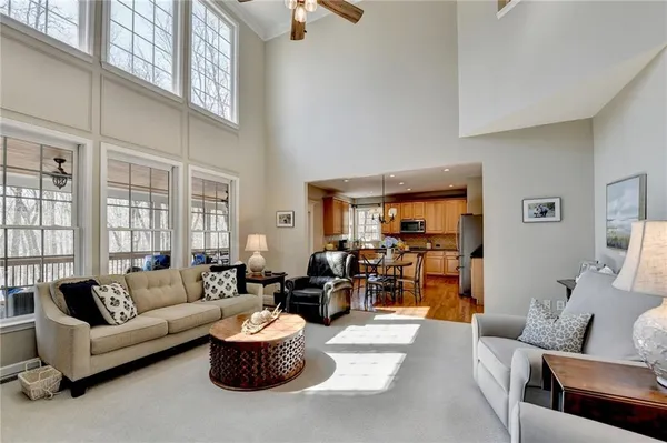 a view of a dining room and livingroom with furniture wooden floor a chandelier