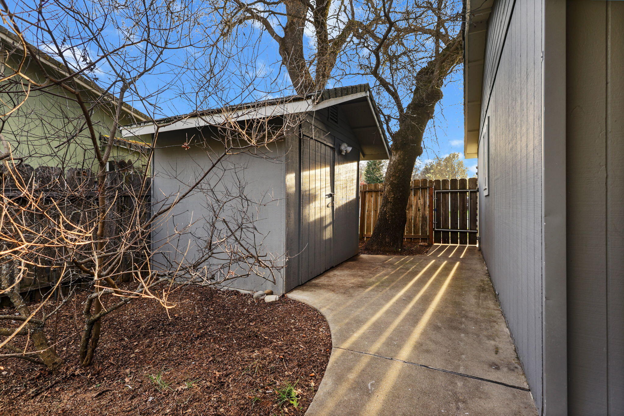 61 Tidmore Lane Redding, CA 96003 - Photo 34 of 38 a view of backyard with wooden fence and large trees