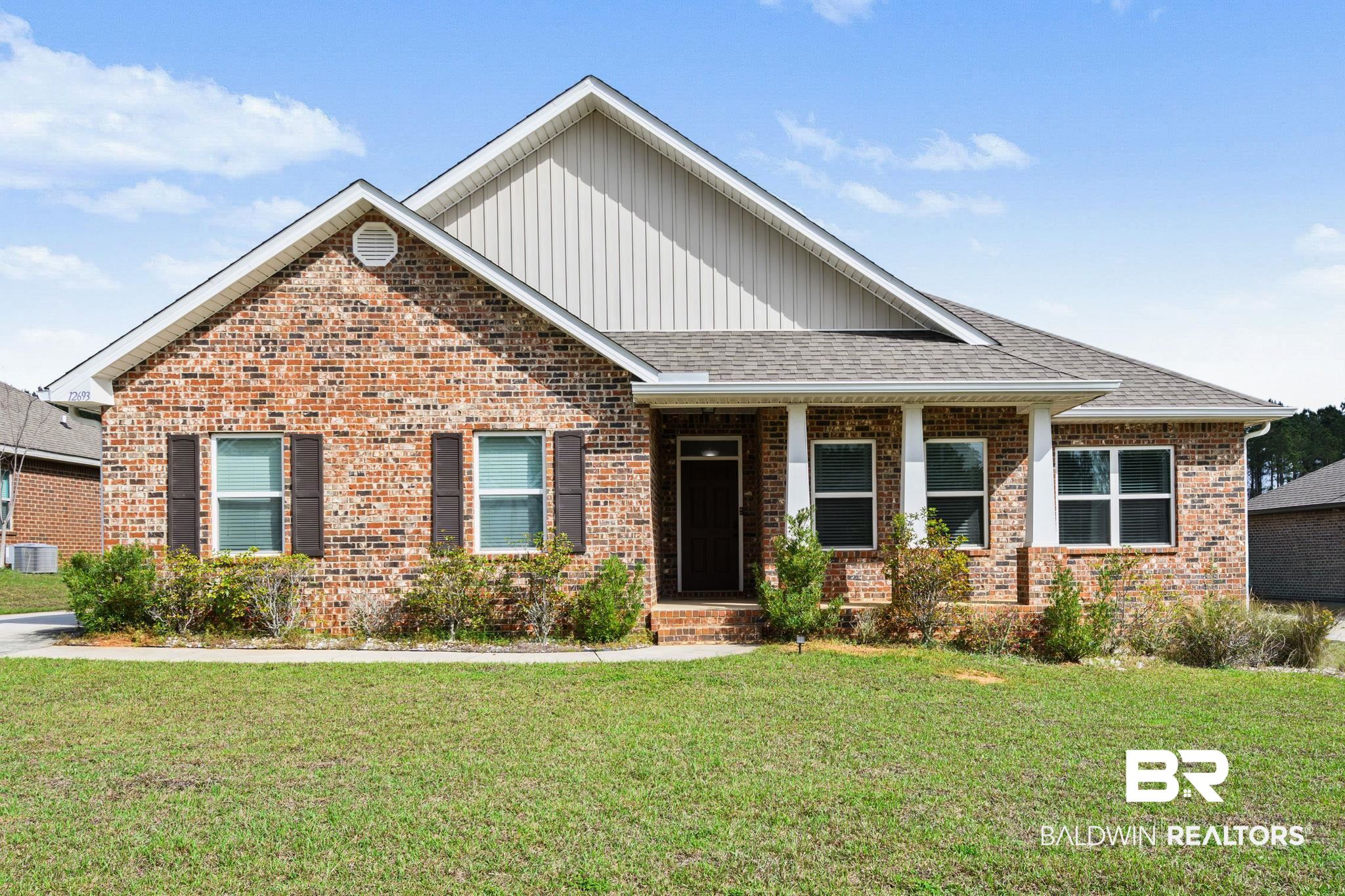 12693 Waxwing Avenue Daphne, AL 36527 - Photo 1 of 43 View of front facade with board and batten siding, roof with shingles, a front lawn, a porch, and brick siding