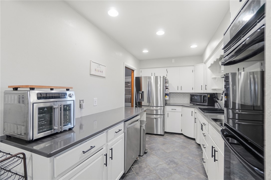 1325 Chelsea Road Troy, OH 45373 - Photo 17 of 42 This sleek kitchen features white cabinetry and modern appliances, perfect for culinary enthusiasts.