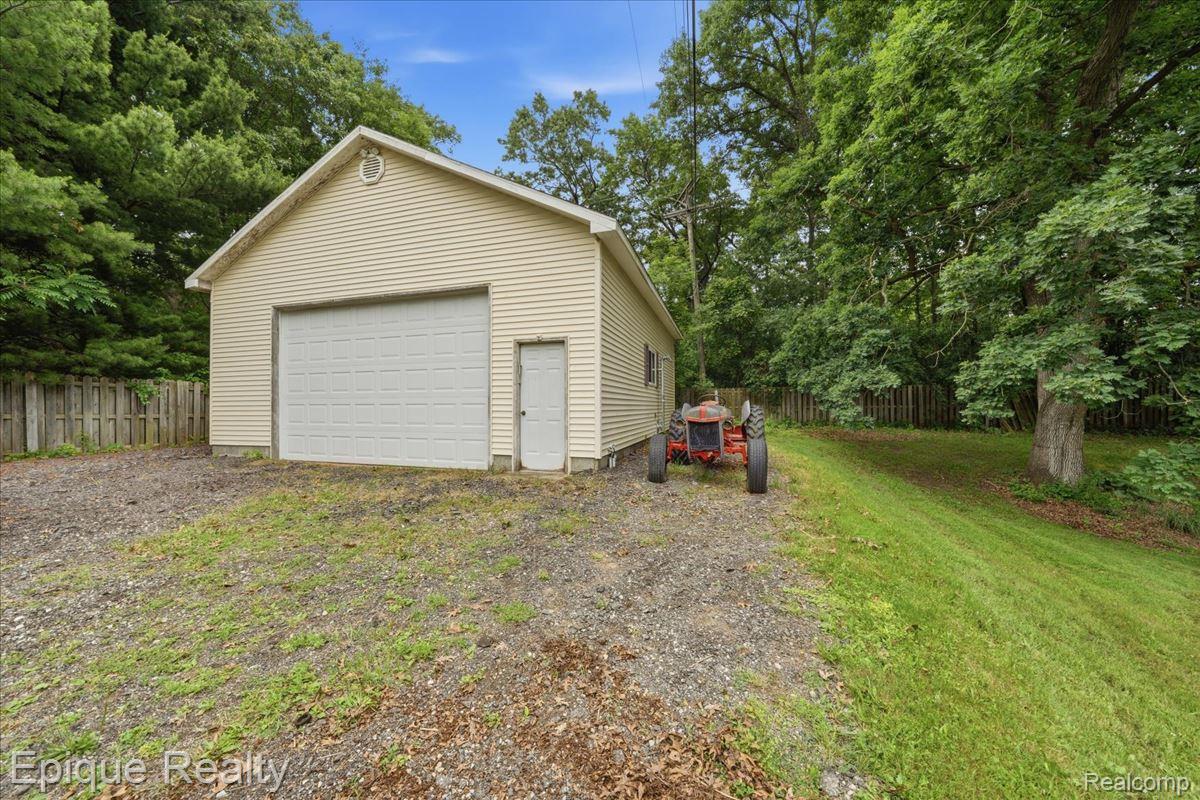 1221 Rhodes Road Lake Orion, MI 48360 - Photo 51 of 72 Detached two-car garage with vinyl siding and an overhead garage door