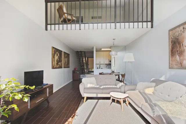 a living room with furniture a flat screen tv and a large window