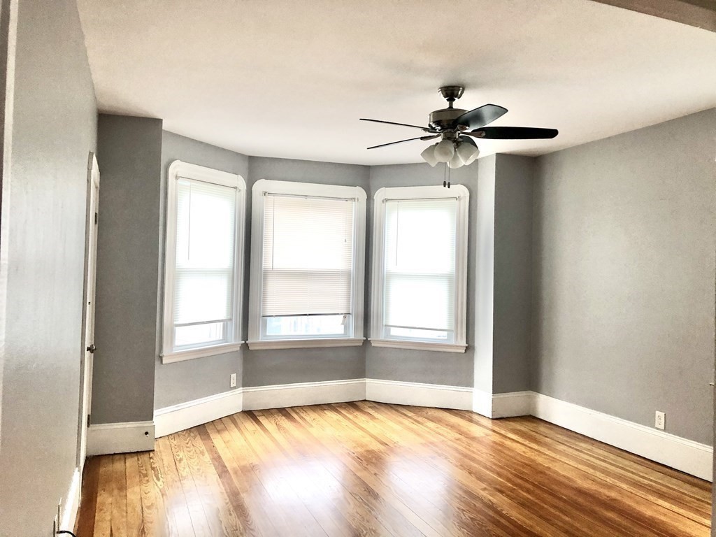 30 Rodney Street, Unit 2 New Bedford, MA 02744 - Photo 1 of 15 a view of an empty room with a window and wooden floor