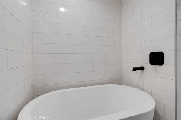 a city view with tall buildings and cars parked on the roadside