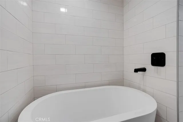 a city view with tall buildings and cars parked on the roadside