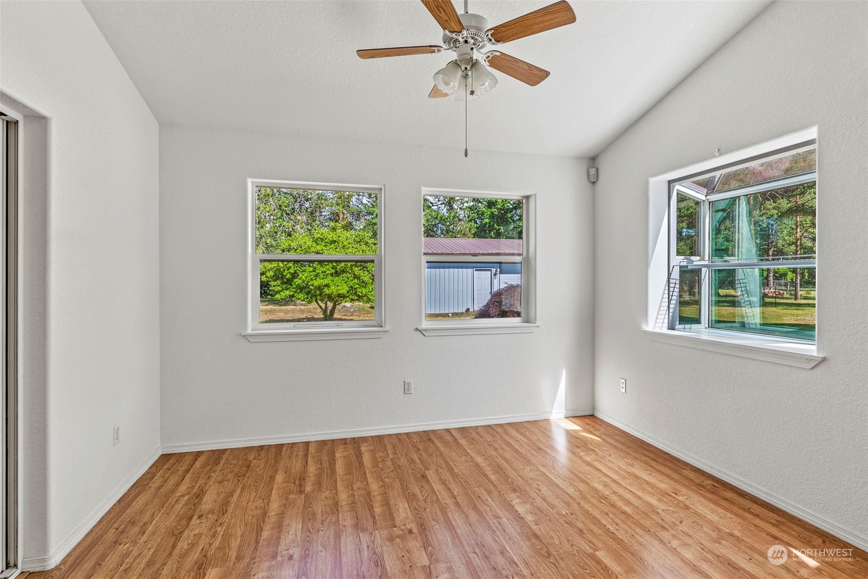 18728 Sams Place Southwest Rochester, WA 98579 - Photo 18 of 28 a view of an empty room with wooden floor and a window