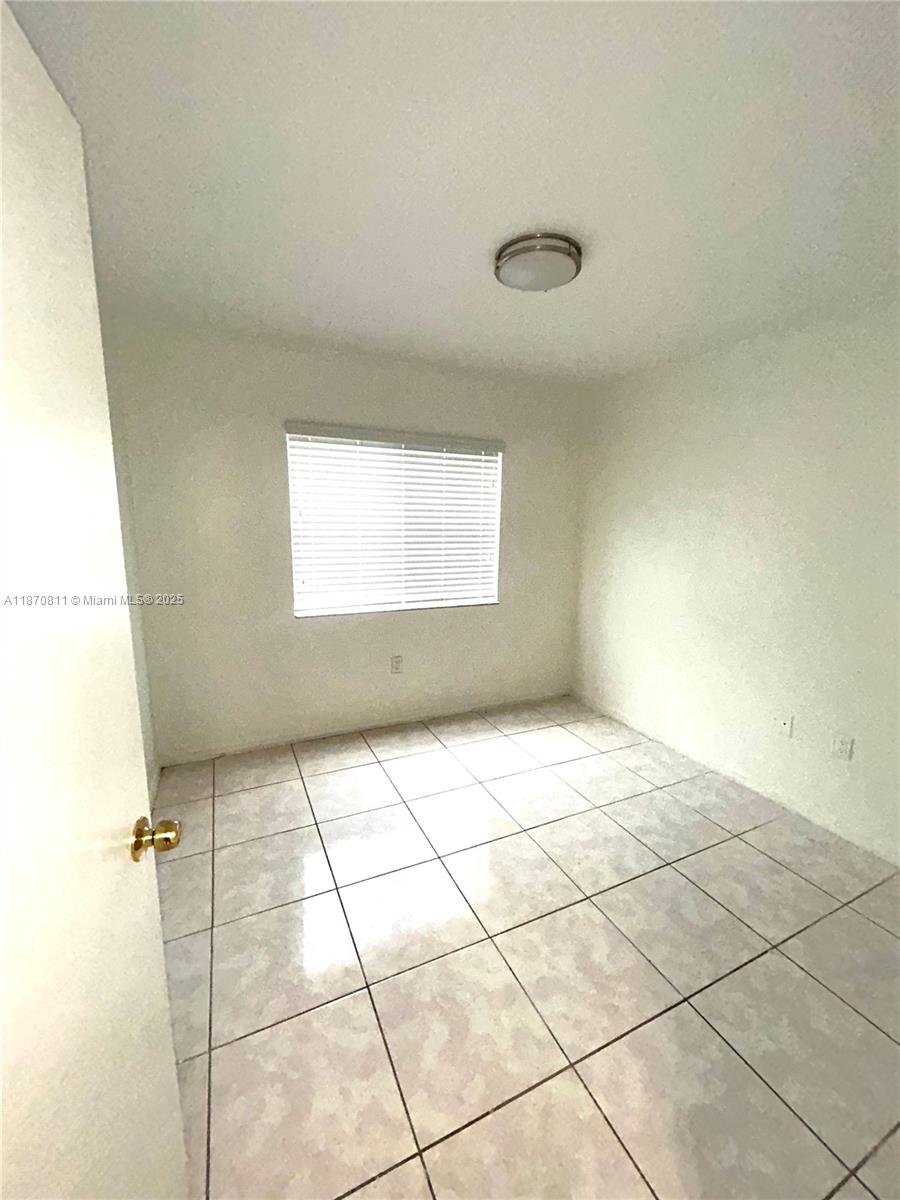 1240 Southeast 28th Court, Unit 101 Homestead, FL 33035 - Photo 16 of 20 a view of an empty room with a window
