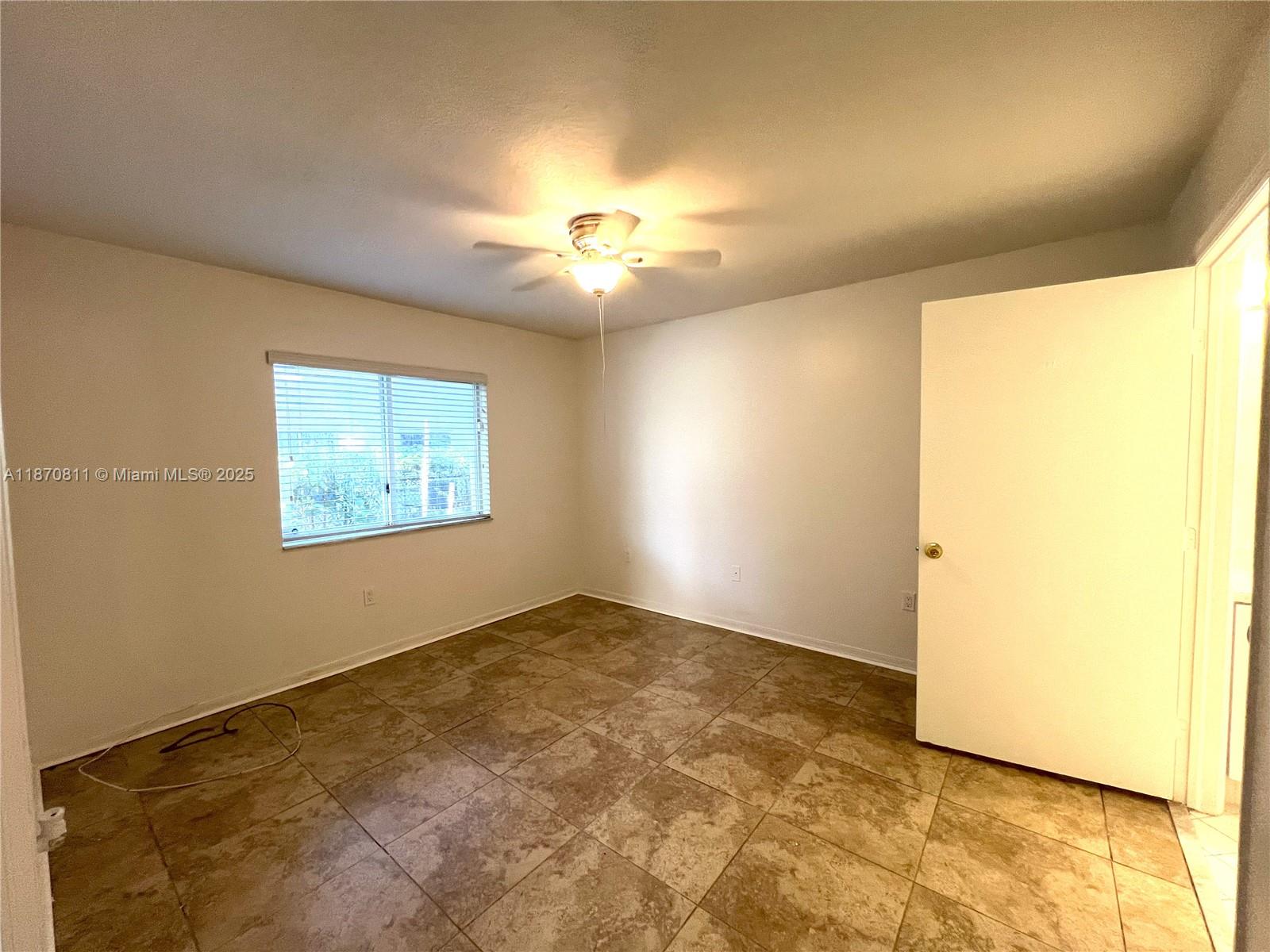1240 Southeast 28th Court, Unit 101 Homestead, FL 33035 - Photo 9 of 20 a view of an empty room and chandelier fan
