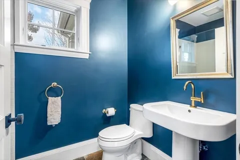 a bathroom with a toilet a sink and mirror