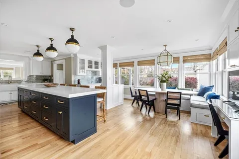a kitchen with a table chairs stove and wooden floor