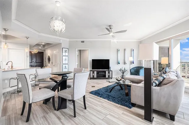 a living room with furniture kitchen view and a flat screen tv