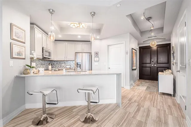 a kitchen with refrigerator and chairs