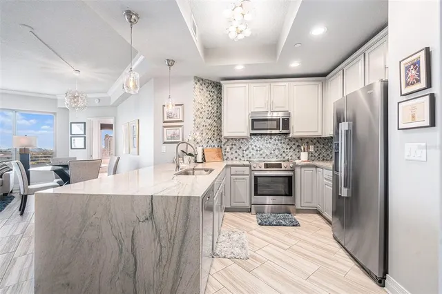 a kitchen with kitchen island a counter top space a sink stainless steel appliances and cabinets
