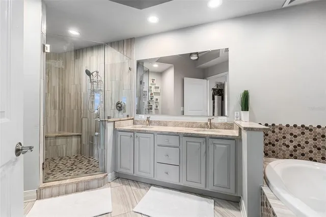 a bathroom with a granite countertop sink mirror and shower