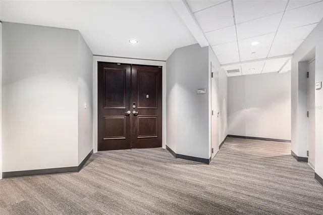 a view of a hallway with wooden floor and a bathroom
