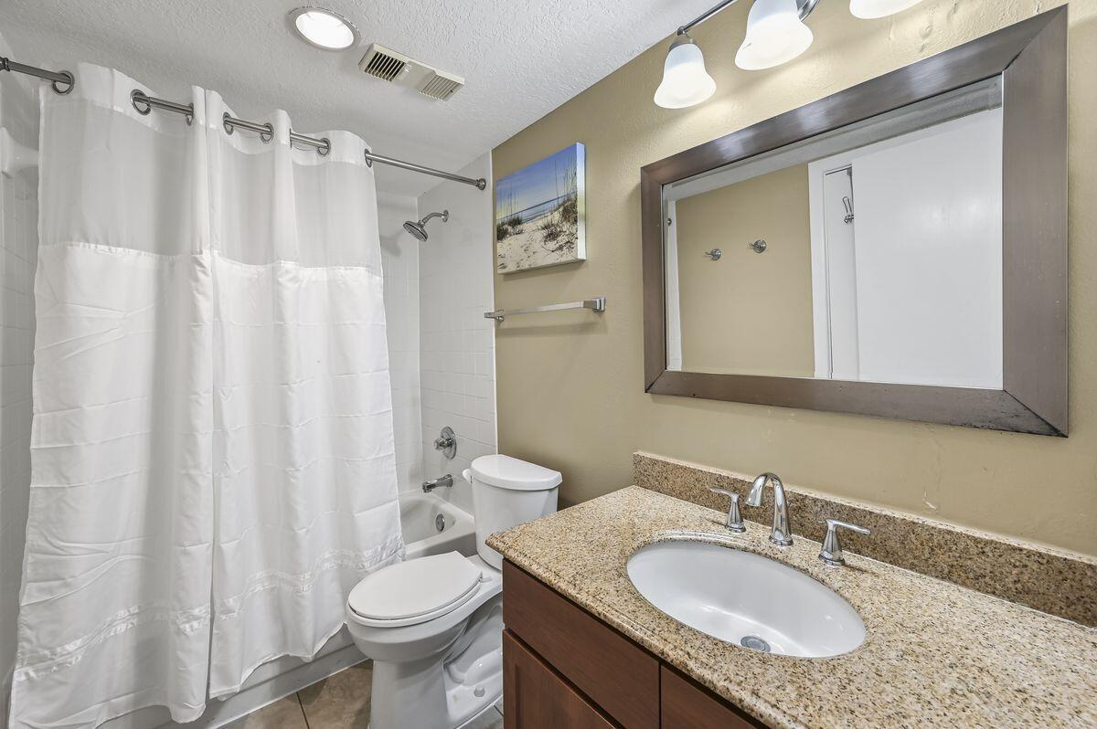 4252 Beachside 2, Unit 252 Miramar Beach, FL 32550 - Photo 19 of 27 a bathroom with a granite countertop toilet sink and mirror