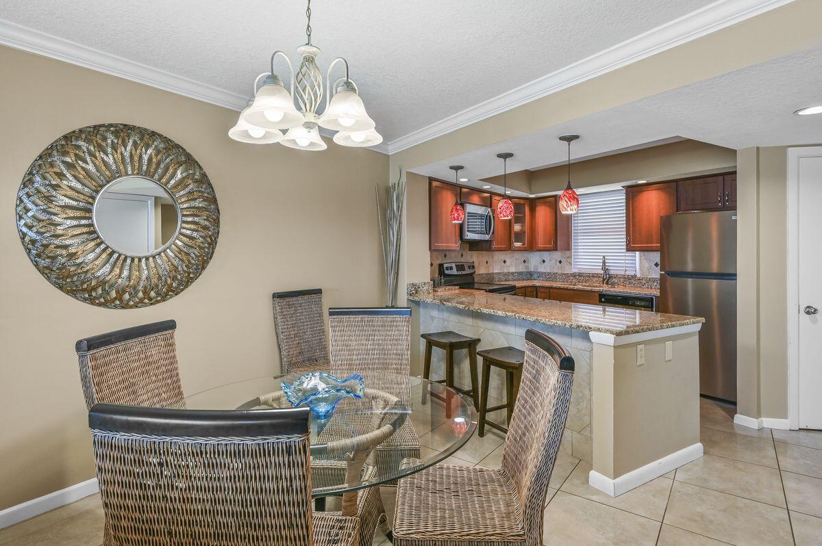 4252 Beachside 2, Unit 252 Miramar Beach, FL 32550 - Photo 6 of 27 a kitchen with stainless steel appliances granite countertop a stove a sink and a dining table