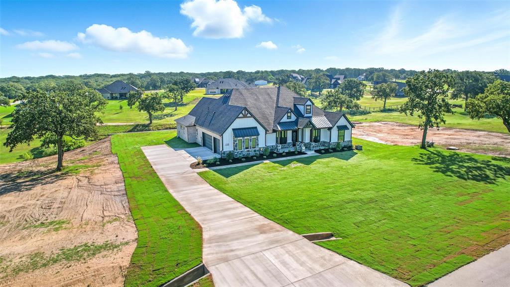 View of front of home featuring driveway, a front lawn, a metal roof, covered porch, and a standing seam roof