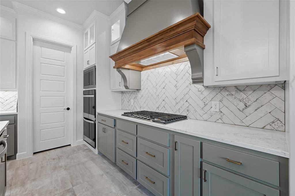 112 La Paloma Way Decatur, TX 76234 - Photo 14 of 37 Kitchen featuring decorative backsplash, premium range hood, light stone countertops, white cabinetry, and glass insert cabinets