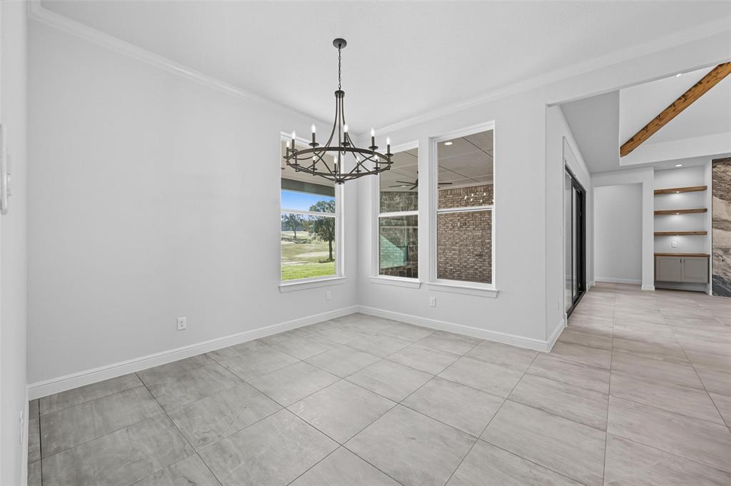 112 La Paloma Way Decatur, TX 76234 - Photo 17 of 37 Unfurnished dining area with a chandelier, beamed ceiling, light tile patterned flooring, and ornamental molding