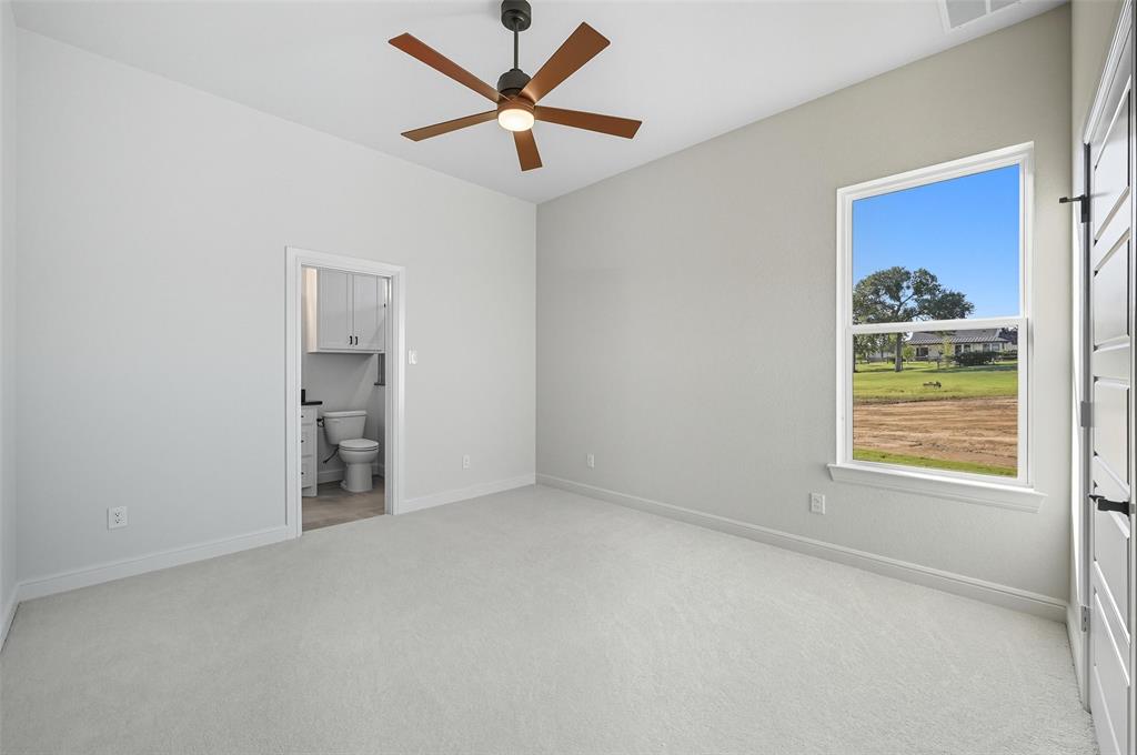 112 La Paloma Way Decatur, TX 76234 - Photo 27 of 37 Unfurnished bedroom with light carpet, a ceiling fan, and ensuite bath