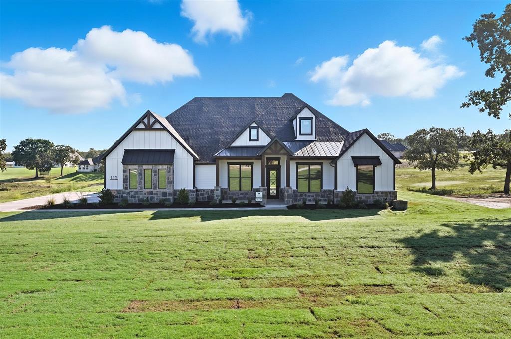 112 La Paloma Way Decatur, TX 76234 - Photo 5 of 37 Modern farmhouse style home featuring a front yard, a standing seam roof, a metal roof, board and batten siding, and stone siding
