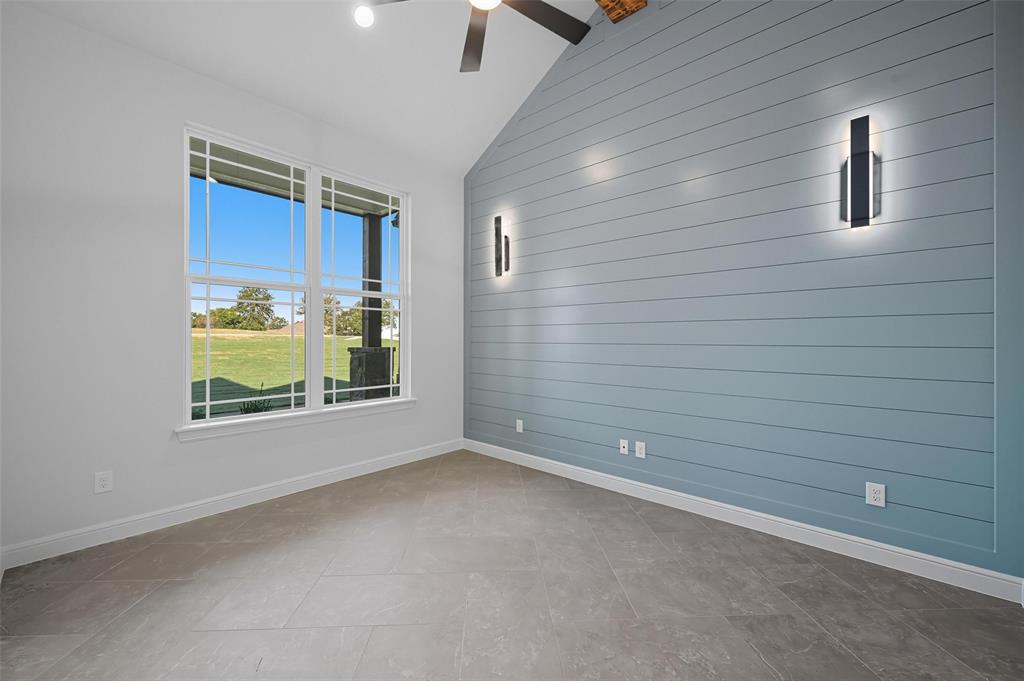 112 La Paloma Way Decatur, TX 76234 - Photo 6 of 37 Unfurnished room featuring wooden walls and vaulted ceiling